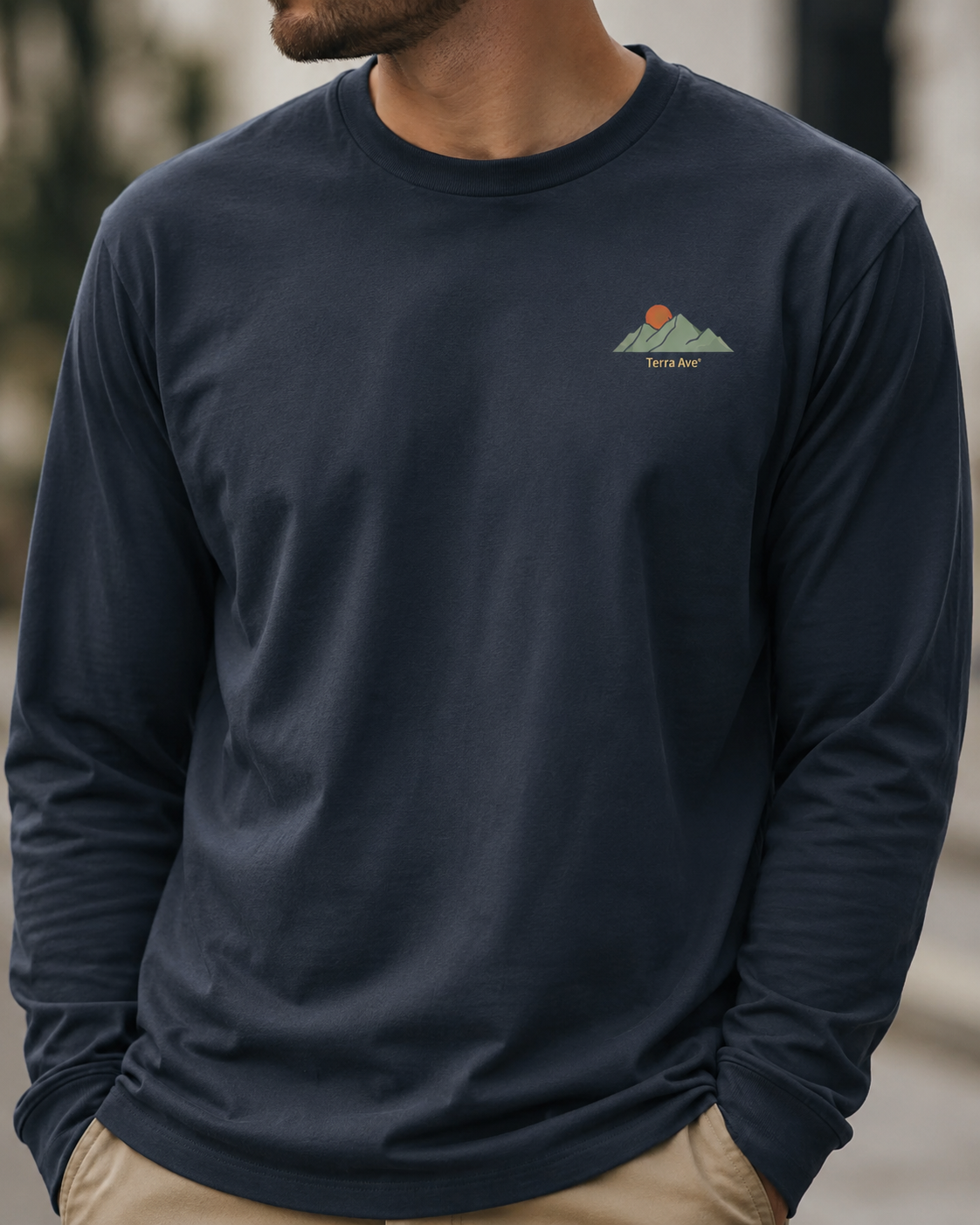 Navy long-sleeve shirt with a logo on a blurred outdoor background
