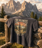 T-shirt with 'The Dolomites Italy' design hanging on a wooden fence with dolomites mountain backdrop