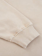 Close-up of a beige sweater sleeve on a matching background