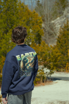Person wearing a navy sweatshirt with 'Earth' design outdoors in nature traveling